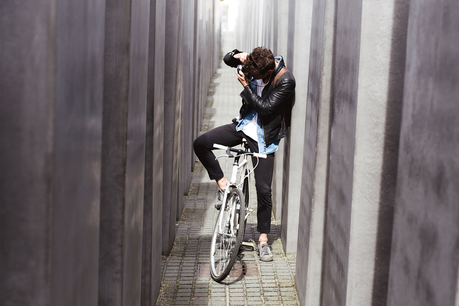 Guy on a bike taking photos at the Holocaust Memorial in Berlin.