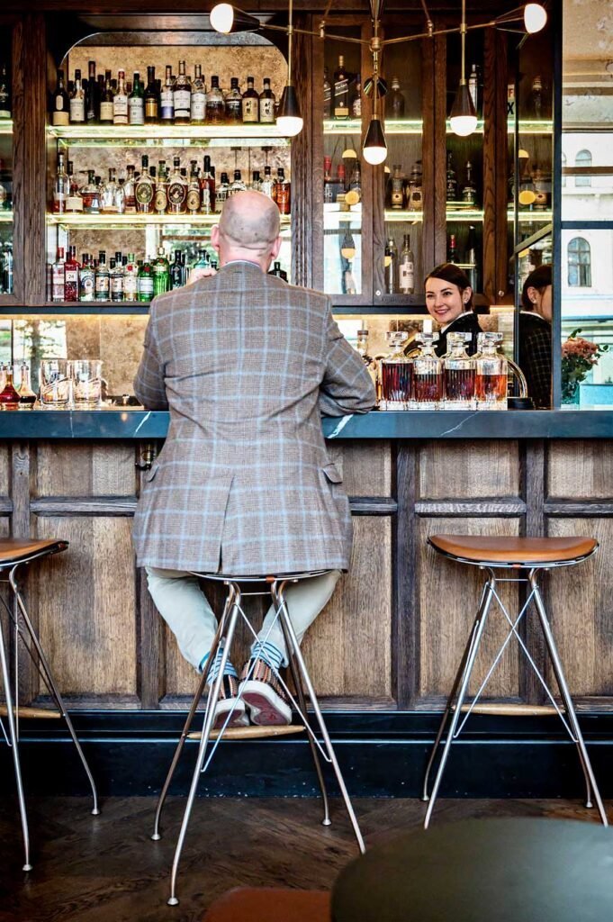 Man sitting at the bar of the Pier 42 cocktail bar (Amerikalinjen hotel) in Oslo, Norway
