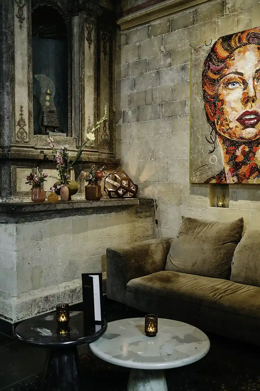Moderne kunst aan de muur en zitjes in de gotische kerk die nu het Kruisherenhotel Maastricht is