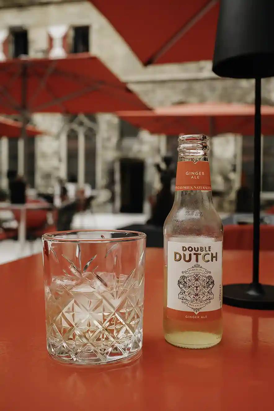 Double Dutch drankje op de binnenplaats van het Kruisherenhotel Maastricht op rode tafels.