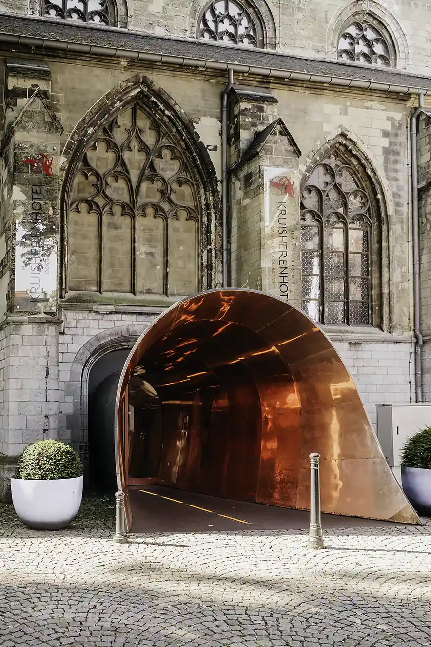 Ingang van het Kruisherenhotel met de oranje koperen tunnel ontworpen door Ingo Maurer