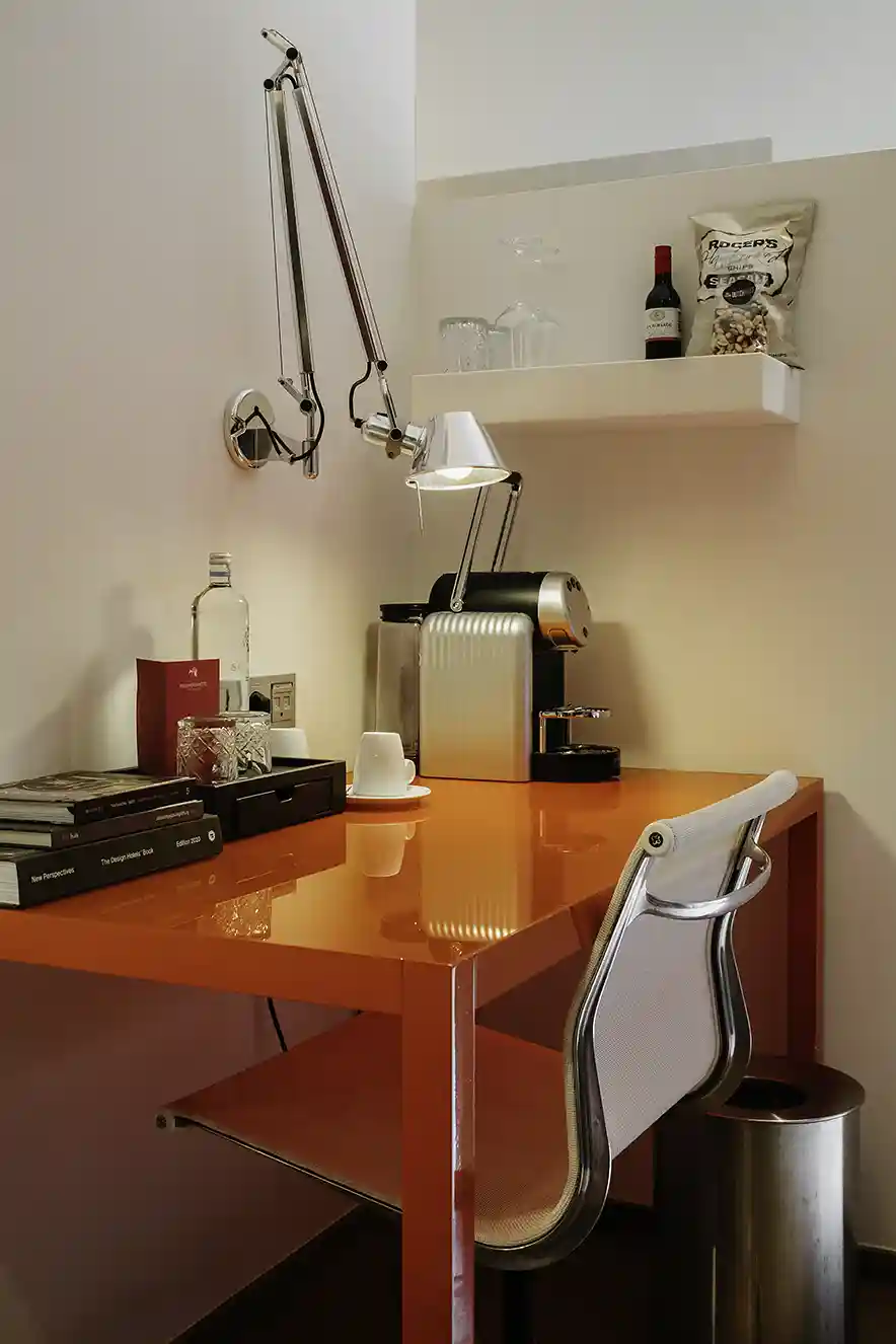 Rood bureau en Artemide lamp in de Signature room van het Kruisherenhotel Maastricht