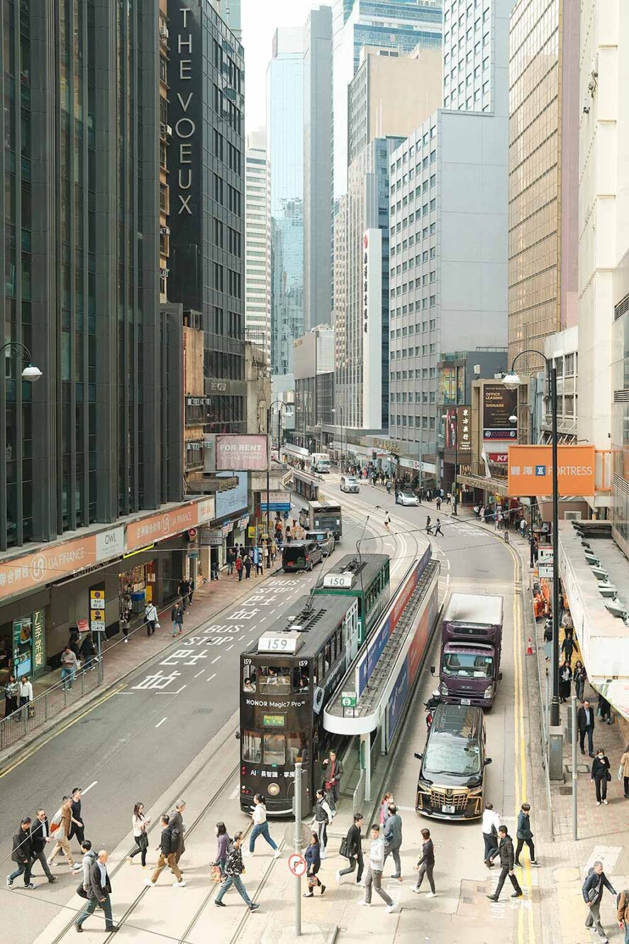 Stad Hong Kong met ding ding tram en mensen die de straat oversteken.
