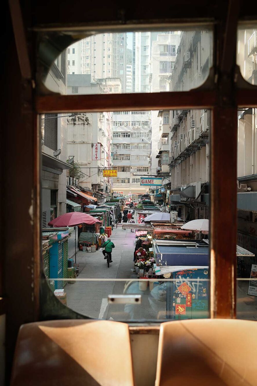 Uitzicht door het raam van een Ding Ding tram in Hong Kong, een van de leukste manieren om rond te reizen in Hong Kong