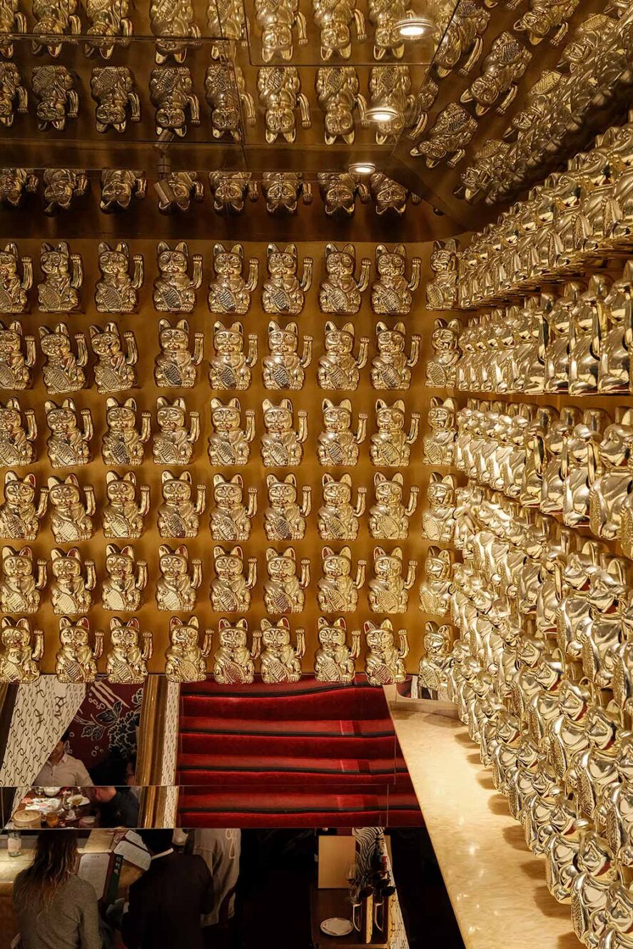 Muur met goudkeurige zwaaiende katten - maneki neko bij restaurant Ho Lee Fook in Hong Kong