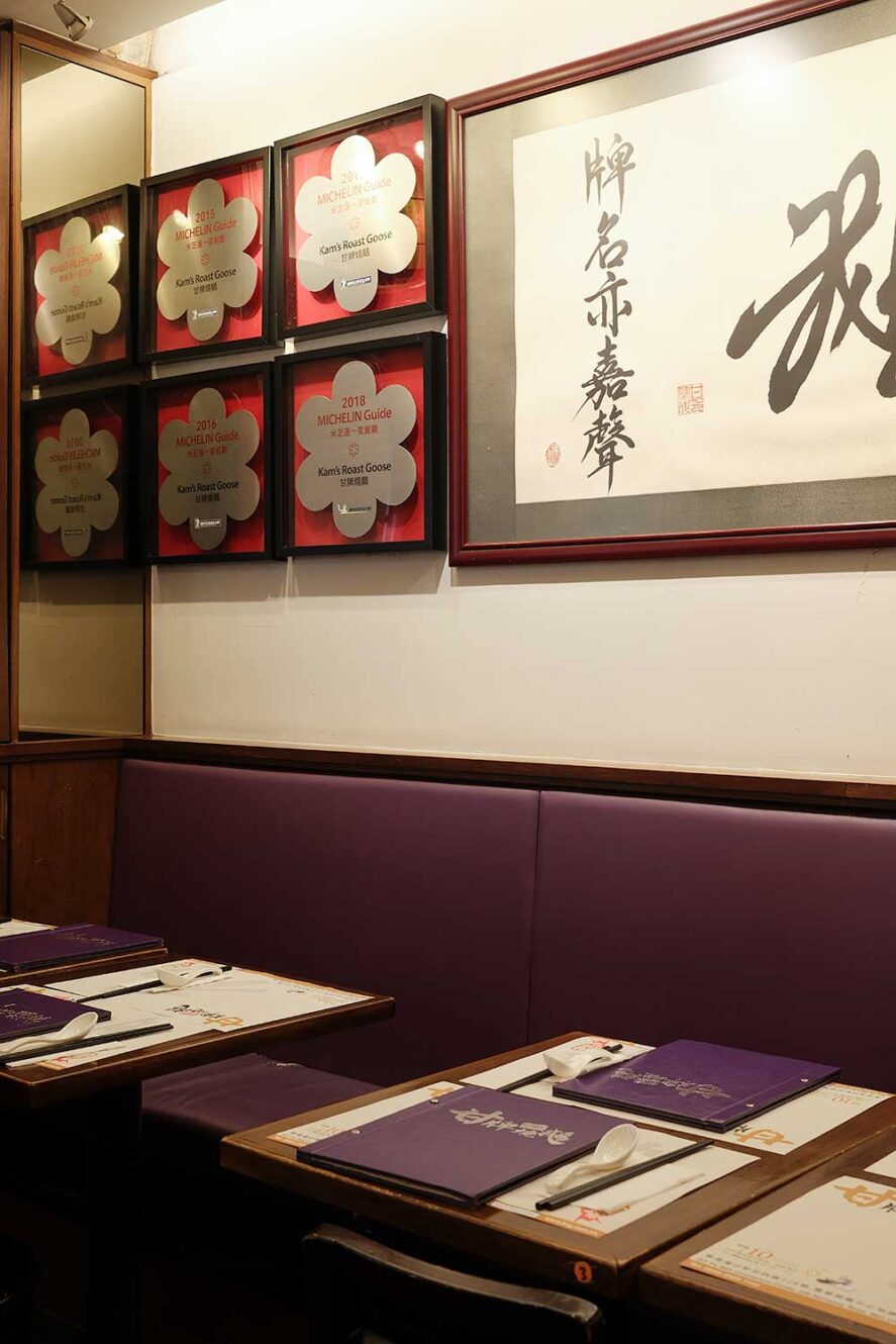 Interieur van Kam's Roast Goose in Wan Chai, Hong Kong met Michelin sterren aan de muur.