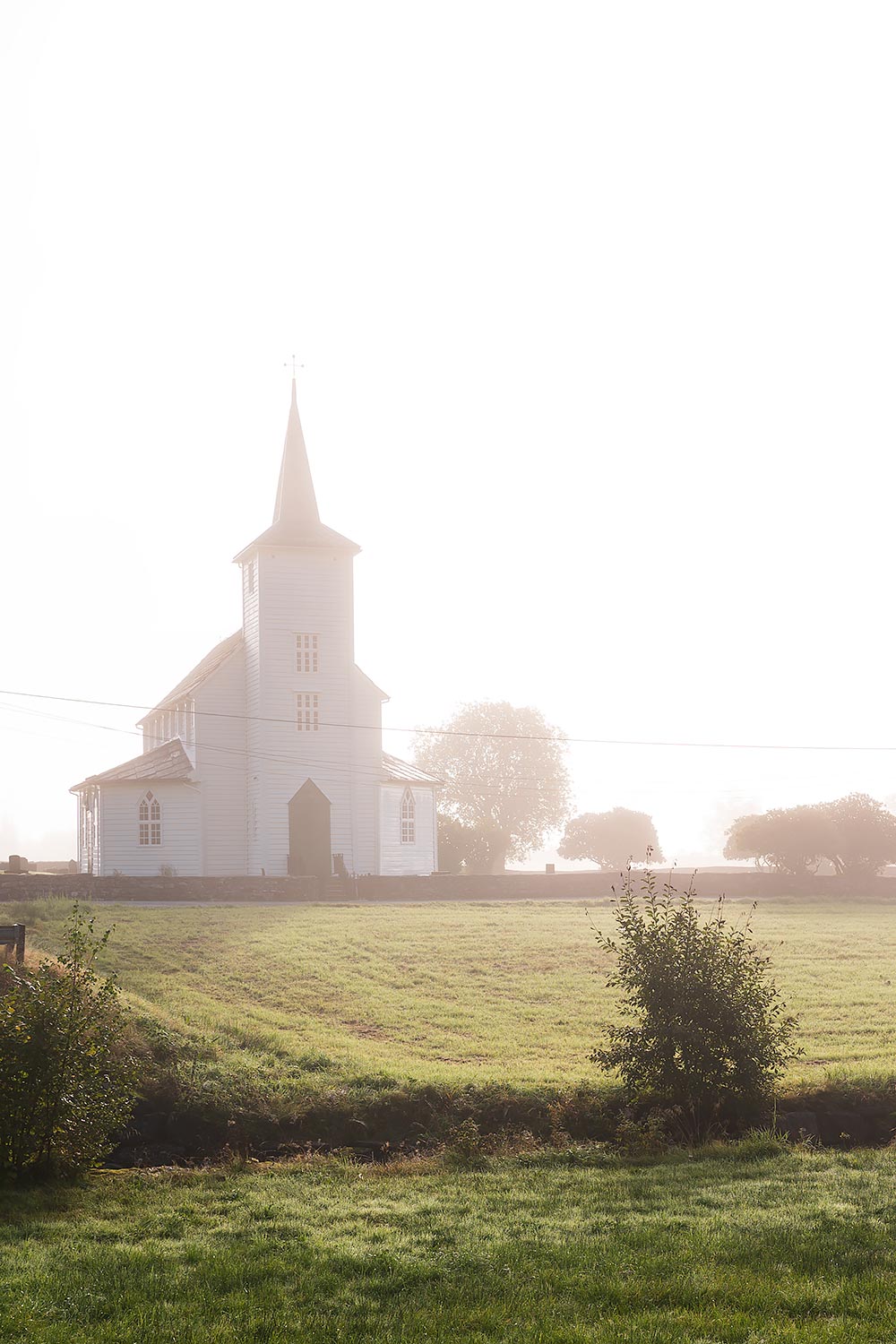 Wit houten kerkje in de mist, onderweg van Bergen naar het Hardangerfjord in Noorwegen