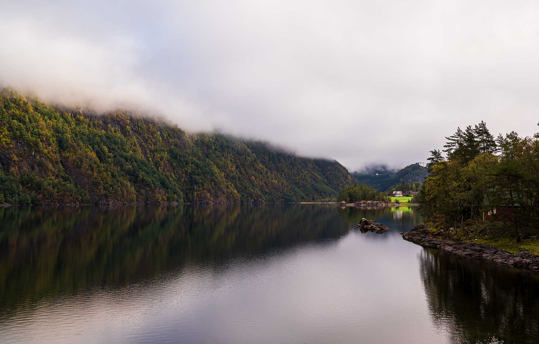 De route van Bergen naar het Sognefjord in Noorwegen brengt je langs een prachtig meer met bomen in verschillende kleuren
